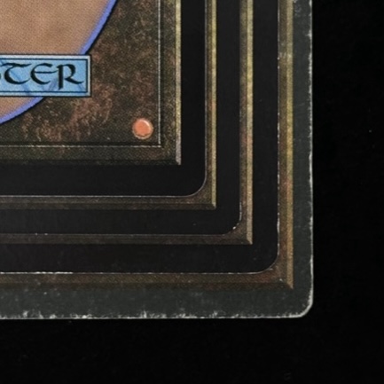 Close-up of stacked card corners showing varying degrees of edge and corner wear across different conditions