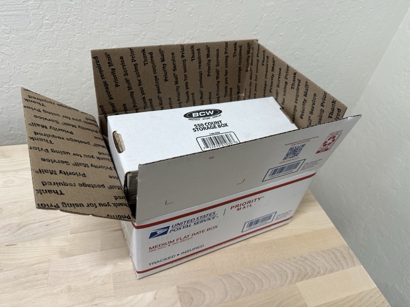 A single BCW 550-count storage box placed inside a top-loading USPS Medium Flat Rate box